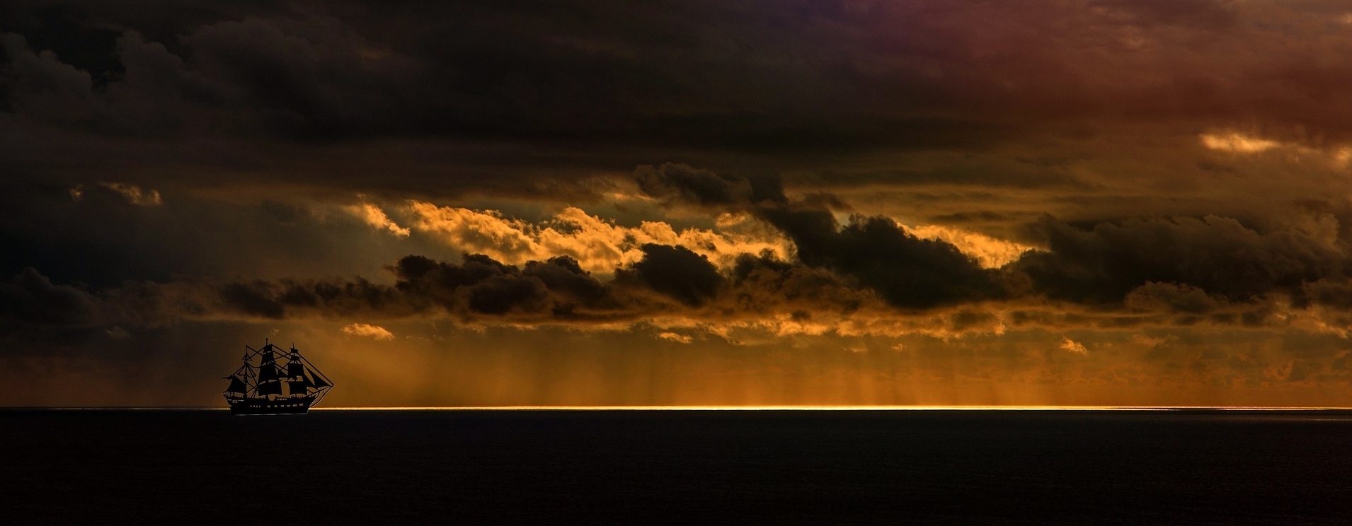 Ein Schiff fährt bei Sonnenuntergang über das Meer